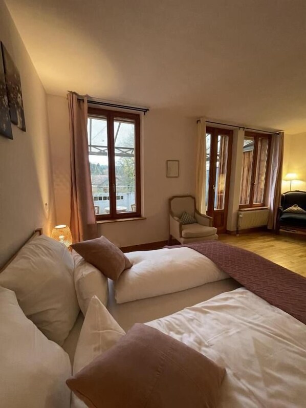 A bedroom with a bed, a chair, and a window.