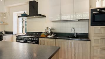 Una cocina moderna con una isla central, electrodomésticos de acero inoxidable y armarios de madera clara.