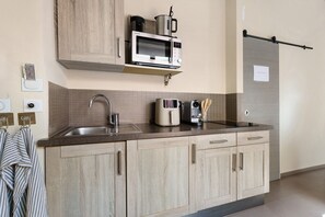 Una cocina moderna equipada con microondas, hervidor de agua y cafetera.