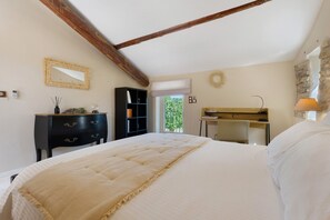 Un dormitorio con cama, cómoda, escritorio y espejo.