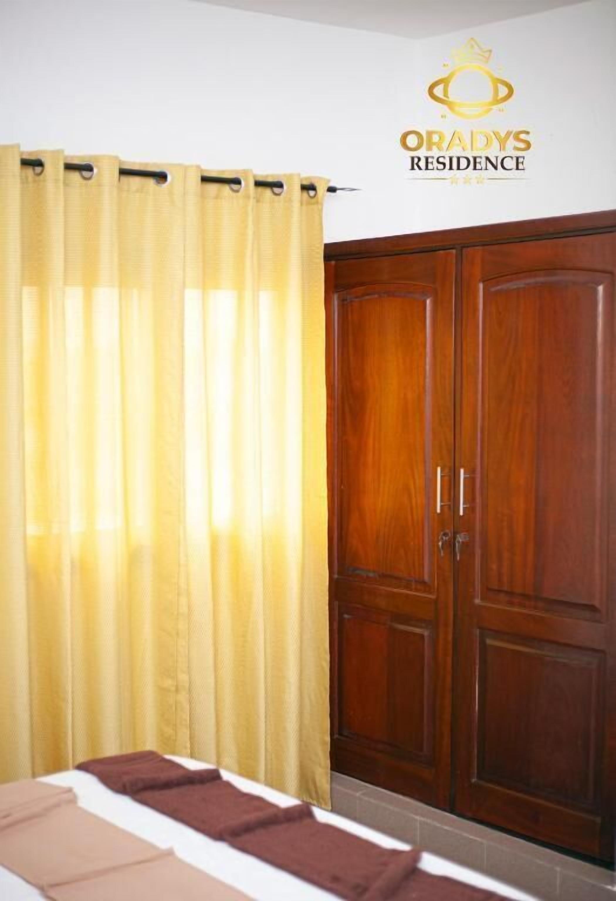 Een hotelkamer met een bed, gordijnen en een kledingkast.