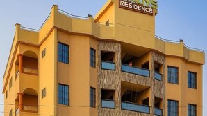 Un edificio de varios pisos con balcones, un cartel que dice 'GRADY'S RESIDENCE' y una entrada con portón.