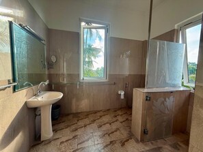 Deluxe trippelrum - utsikt mot poolen | Badrum | Dusch, handdukar, tvål och toalettpapper