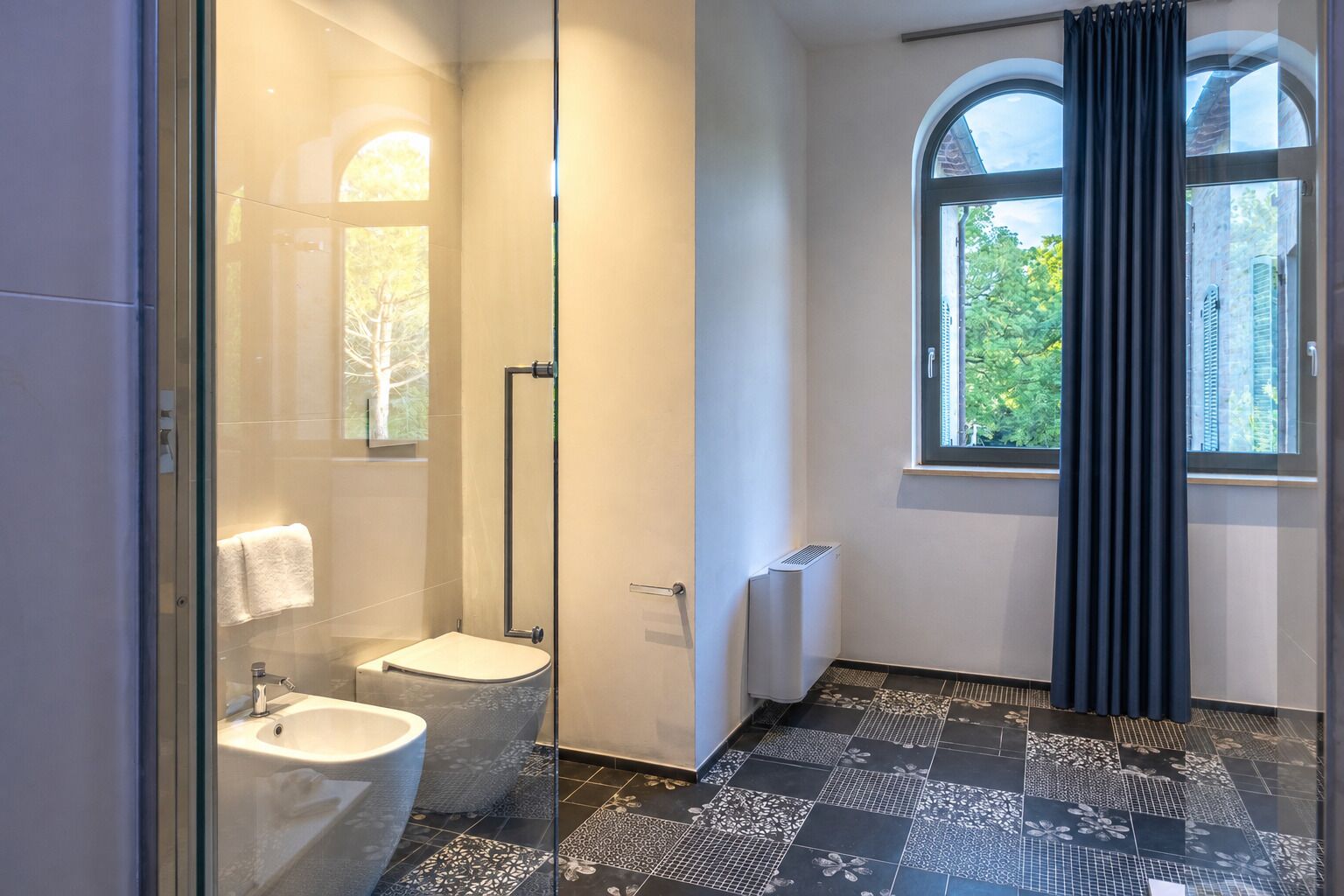 Un baño moderno con cabina de ducha de vidrio, inodoro y bidé.