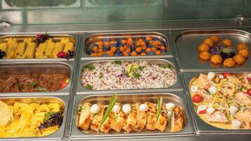 Un bufé con diversas opciones de comida, incluyendo arroz, carne y vegetales.