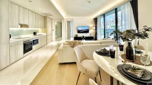 Een moderne keuken met een eethoek, een flatscreen televisie en uitzicht over de stad.