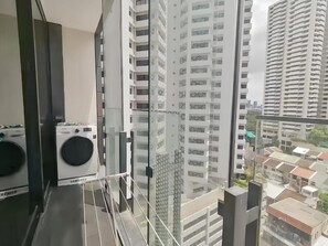 A high-rise building with a view of other buildings and a balcony with a Samsung washing machine. - Circle Sukhumvit 11 Bangkok (Krung Thep Maha Nakhon)