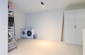 A laundry room with a washing machine, dryer, and a shelf with cleaning supplies. - Golden View 2472 Private Pool & Jacuzzi (Manilva)