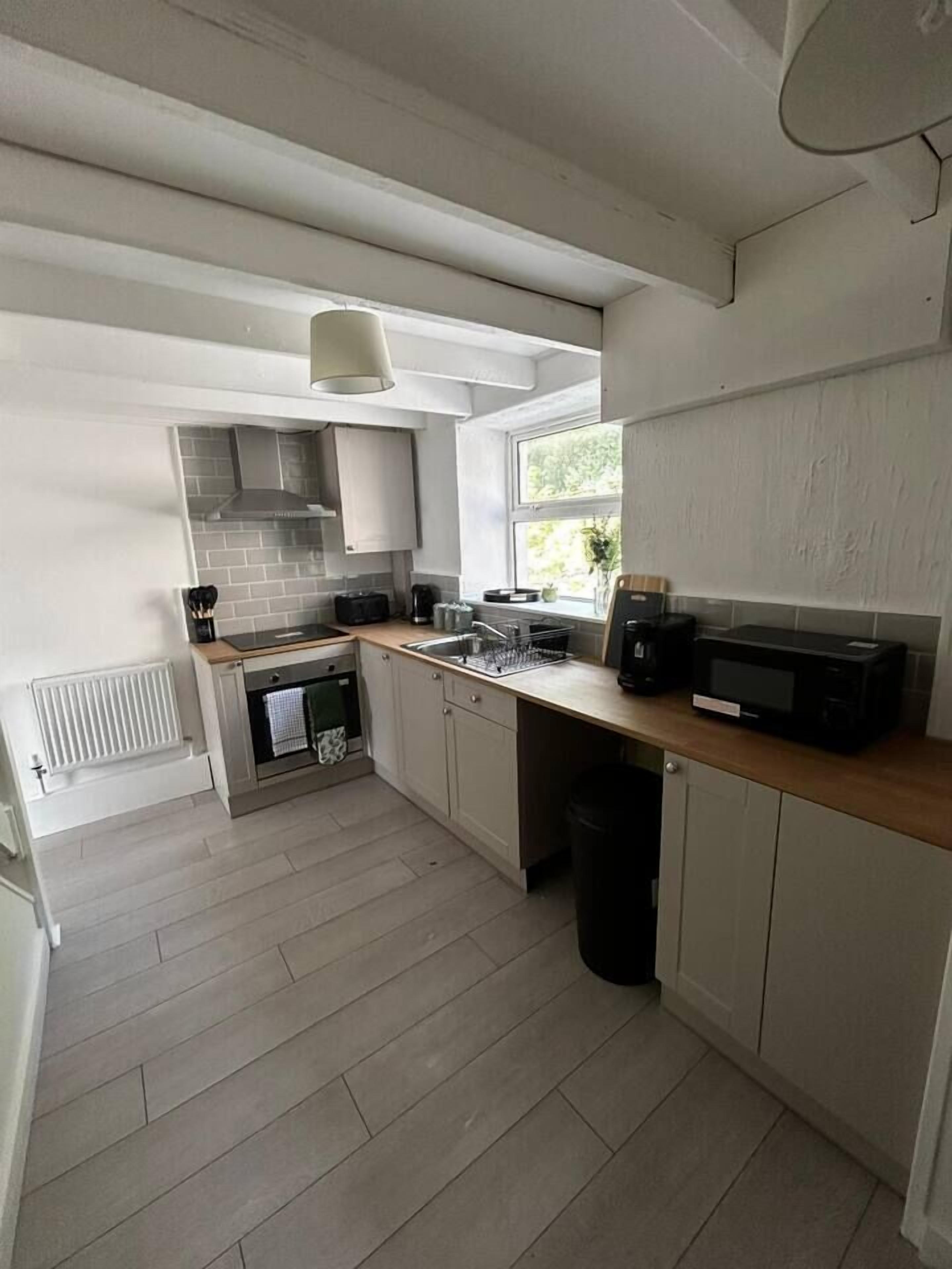 A kitchen with a built-in oven, microwave, and a window providing natural light.