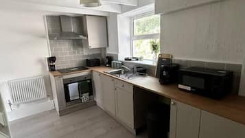 A kitchen with a built-in oven, microwave, and a window providing natural light.