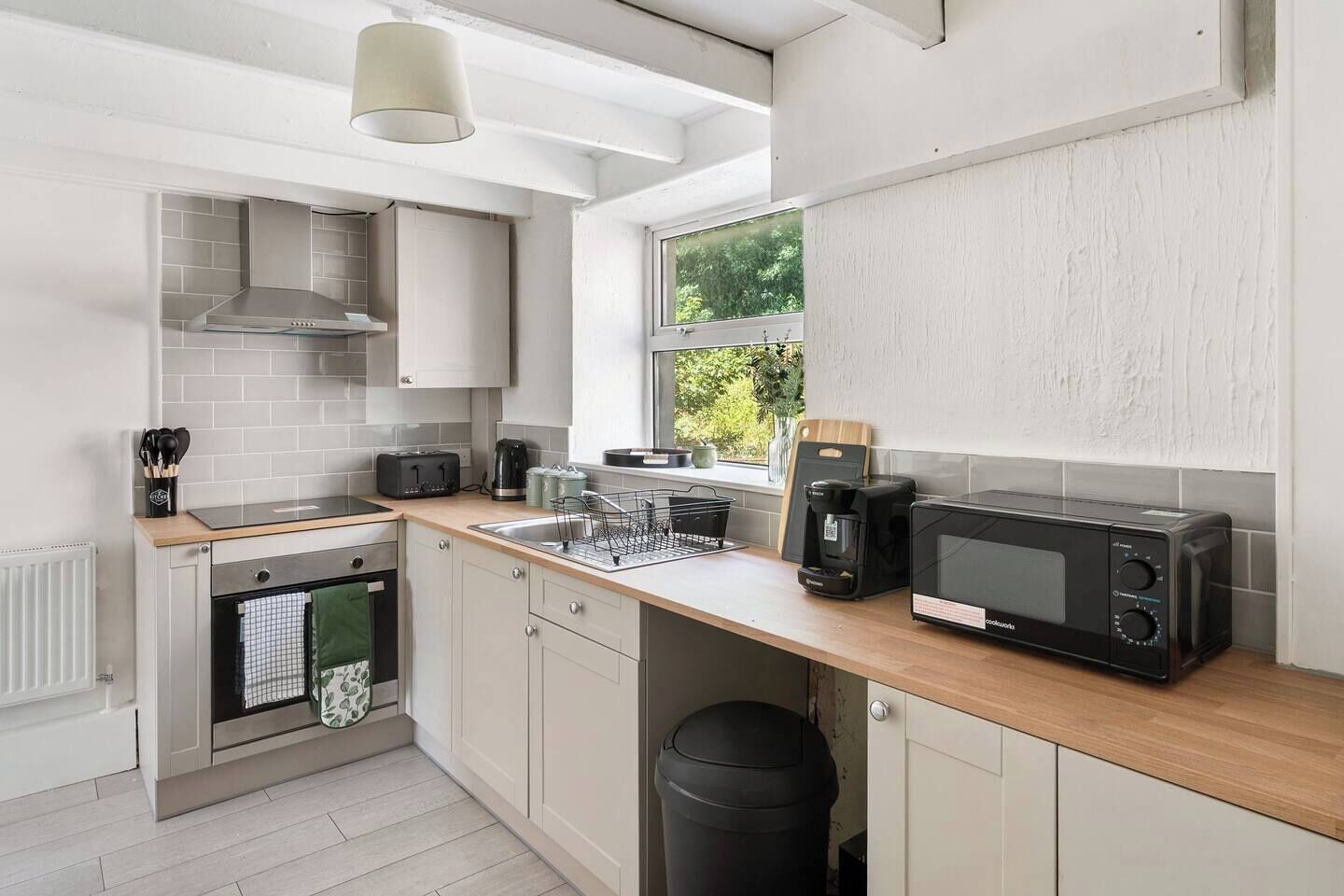 A compact kitchen with a toaster, coffee maker, and microwave.