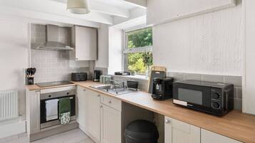 A compact kitchen with a toaster, coffee maker, and microwave.