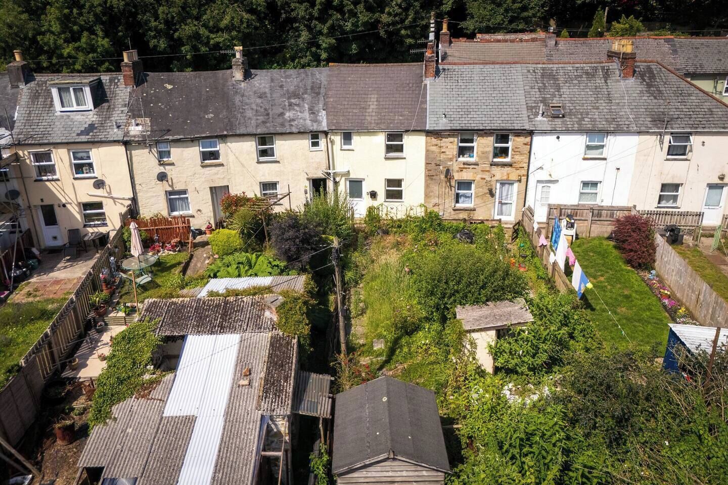 A residential area with terraced houses, a fenced garden, and a clothesline.