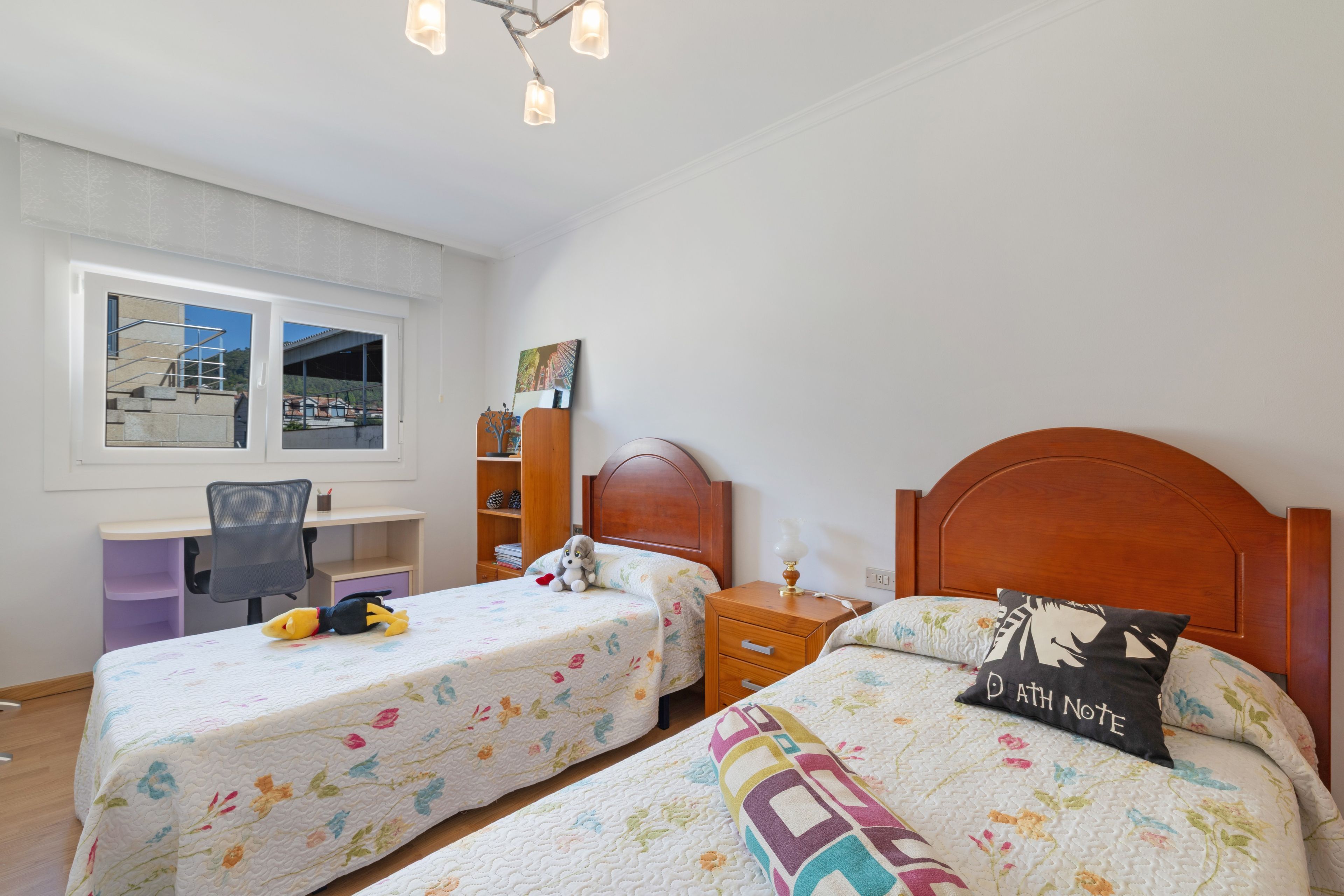 Une chambre avec deux lits, un bureau et une chaise.