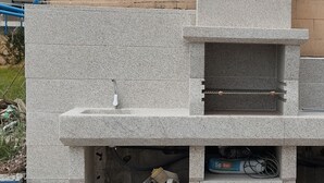 Eine Baustelle mit einer Betonkonstruktion, die ein Waschbecken und ein Regal zeigt.