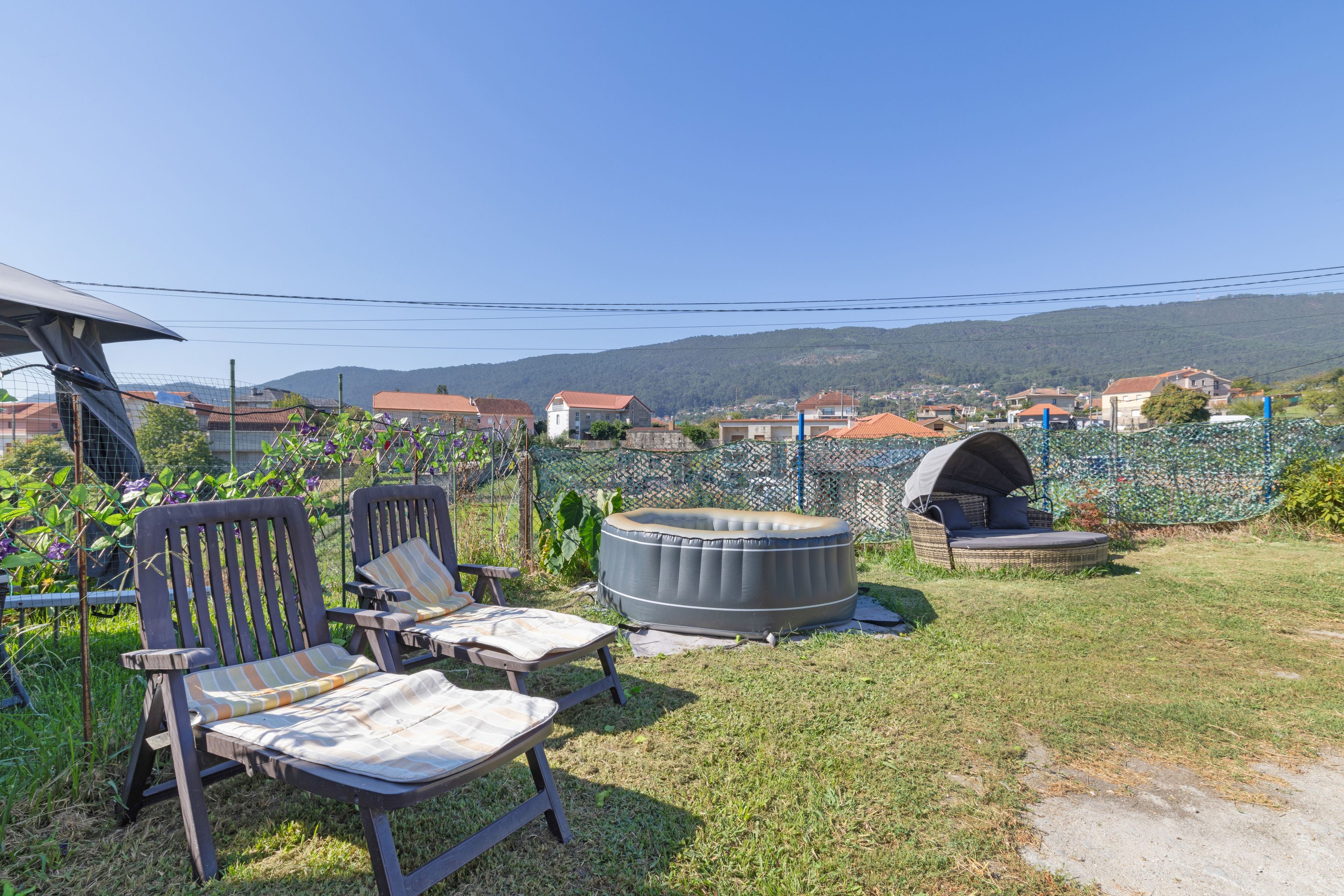 Een terras met stoelen, een ronde tafel, een barbecue en een tent.