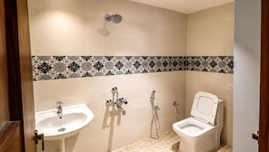 A bathroom with a sink, toilet, and shower. - Royal Suites in Marathalli Bangalore (Bengaluru)