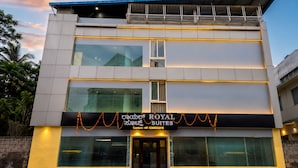 A hotel with a modern design, featuring a flat roof, large windows, and a contact number displayed. - Royal Suites in Marathalli Bangalore (Bengaluru)