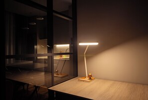 Ein moderner Büroraum mit Schreibtisch, Lampe und Glastrennwand.