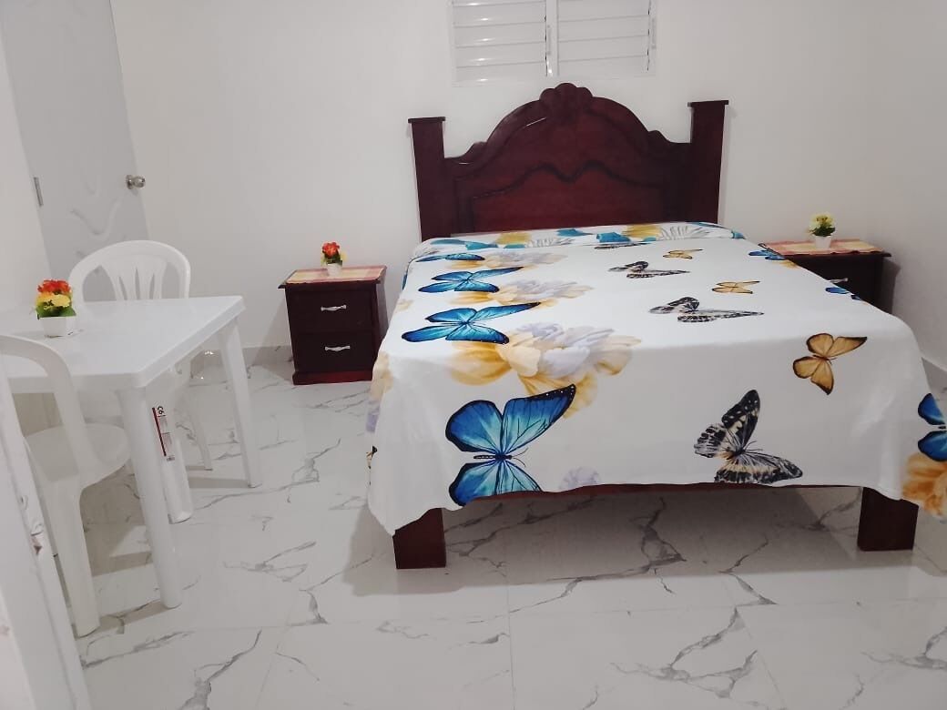 Um quarto com uma cama, uma mesa e uma cadeira.