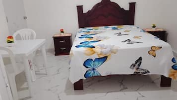 Um quarto com uma cama, uma mesa e uma cadeira.