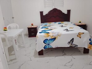 Ein Schlafzimmer mit einem Bett, einem Schreibtisch und einem Stuhl.