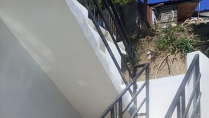 A staircase with metal railings leading to a white wall.