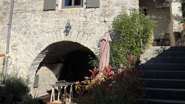A stone building with a central archway, multiple windows with shutters, and a staircase leading to an upper level. - CHARMING, air-conditioned house with a private, fully secured saltwater pool. (Chandolas)