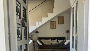 A hallway leading to a bedroom with a bed, a staircase, and a patterned rug. - CHARMING, air-conditioned house with a private, fully secured saltwater pool. (Chandolas)