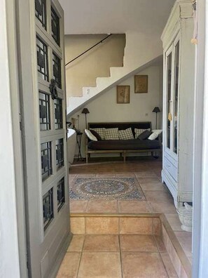 A hallway leading to a bedroom with a bed, a staircase, and a patterned rug. - CHARMING, air-conditioned house with a private, fully secured saltwater pool. (Chandolas)