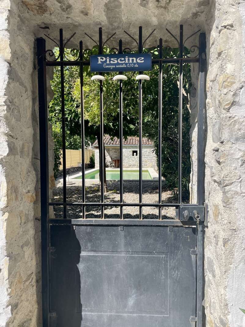 A gated entrance with a sign reading 'Piscine' indicating a swimming pool area.
