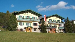 Ein Hotel mit zweigeschossigen Gebäuden, Balkonen mit Blumenkästen und einer Flagge.