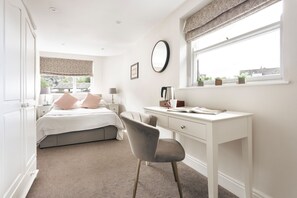 A bedroom with a bed, bedside table, lamp, desk, chair, window, and a view of the outside. - Room Near Lake Windermere (Ambleside)