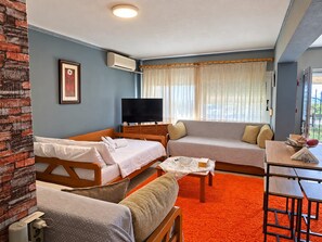 Ein Hotelzimmer mit Bett, Sofa, Fernseher und einem Tisch mit Stuhl.