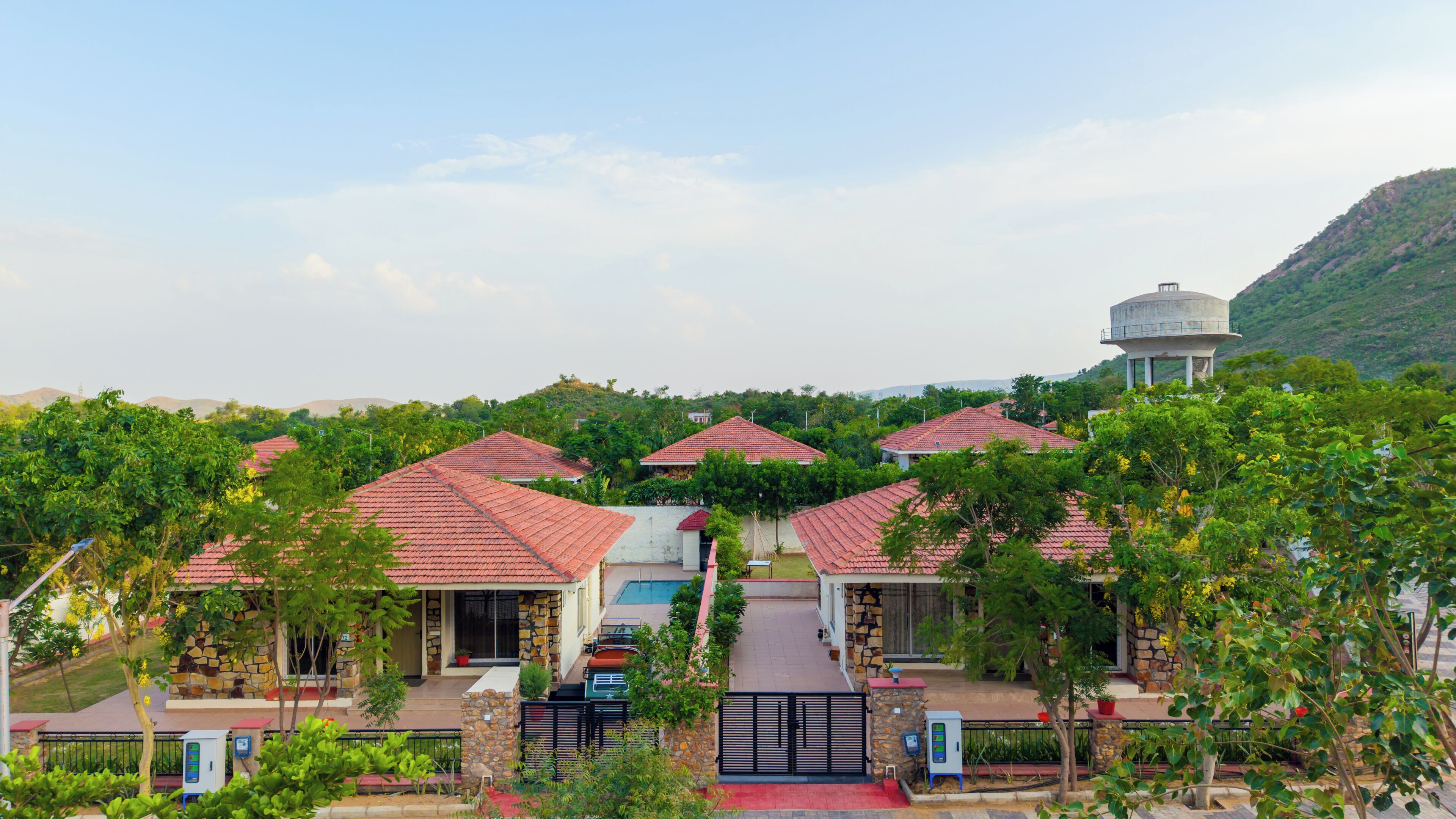 A residential area with multiple houses, a central gate, and a water tower in the background.