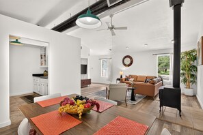 A spacious living area with a dining table set for a meal, a sofa, and a television. - Dripping Springs The Wrangler | *NEW* Hill Country Escape (Dripping Springs)