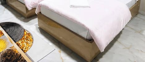 Habitación de hotel con dos camas, un cuadro en la pared y una ventana con cortinas.