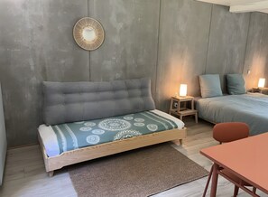 Una camera da letto con un letto, comodini, un divano e un tavolo.