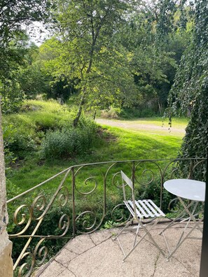 A garden patio with a metal railing, a white table, and a bench.