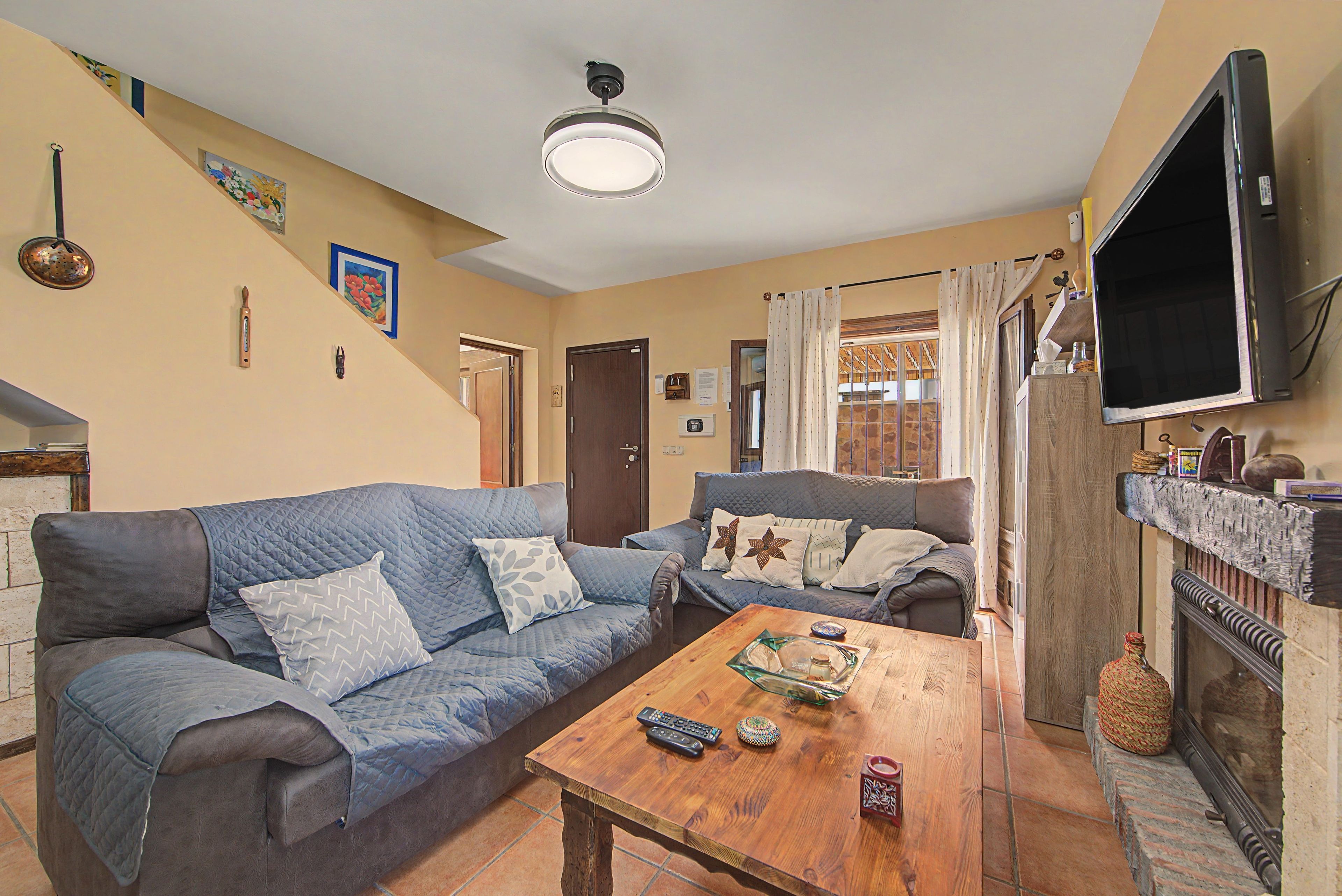 A living room with two sofas, a coffee table, a fireplace, and a television.
