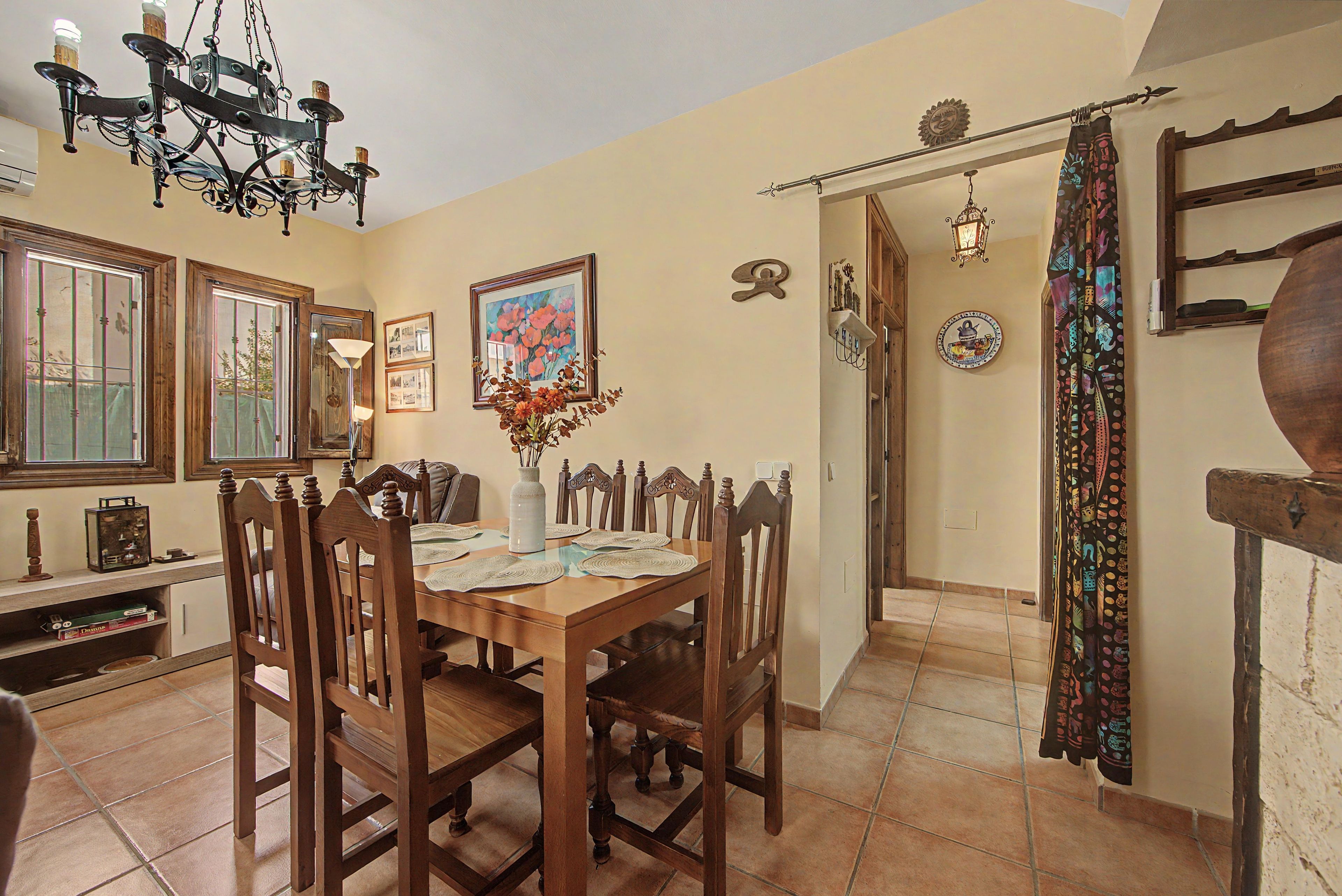 A dining area with a wooden table, chairs, and a chandelier.