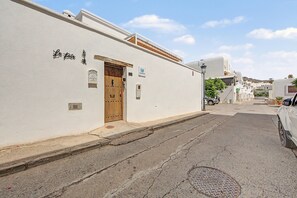 A street view of a building with a wooden door, a mailbox, and a sign indicating a business. - Country House 'La Pita Casa Rural' with Mountain View, Wi-Fi and Air Conditioning (Felix)