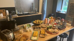 Eine Küche mit einer Holzausziehtafel, verschiedenen Lebensmitteln, einem Toaster und einem Kühlschrank.