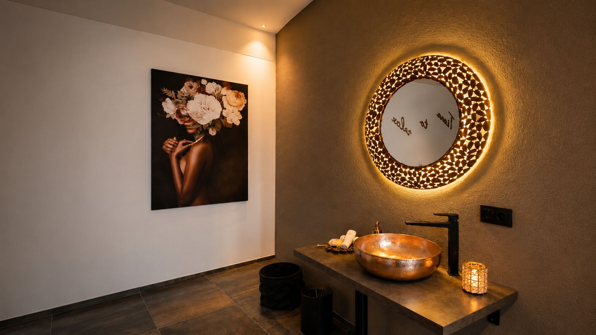 Ein modernes Badezimmer mit einem Kupferspülbecken, einem runden Spiegel mit strukturierter Rahmen sowie einem Wandbild.