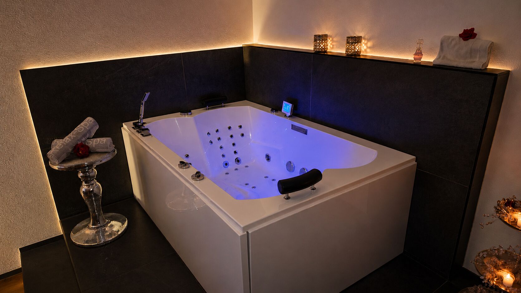 Un baño moderno con una bañera independiente, una copa de vino y una toalla con adorno de rosa.