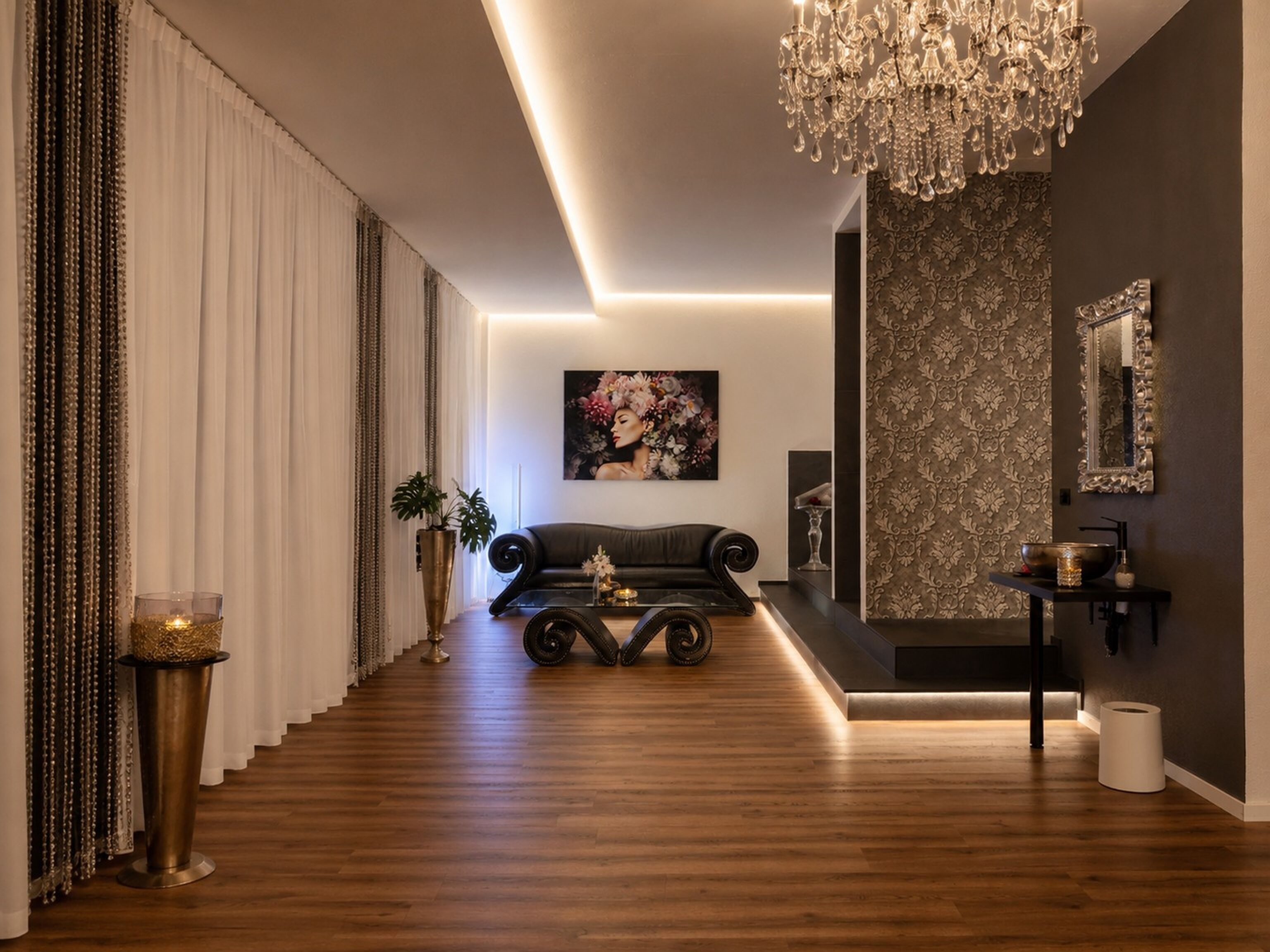 A modern interior with a leather sofa, a chandelier, and a patterned wall.