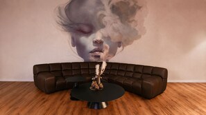 Una sala de estar moderna con un sofá curvo, una mesa de centro negra redonda y un jarrón decorativo.
