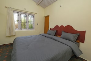A room with a bed, a window with a view, and a door. - Mistora Valley (Ooty)