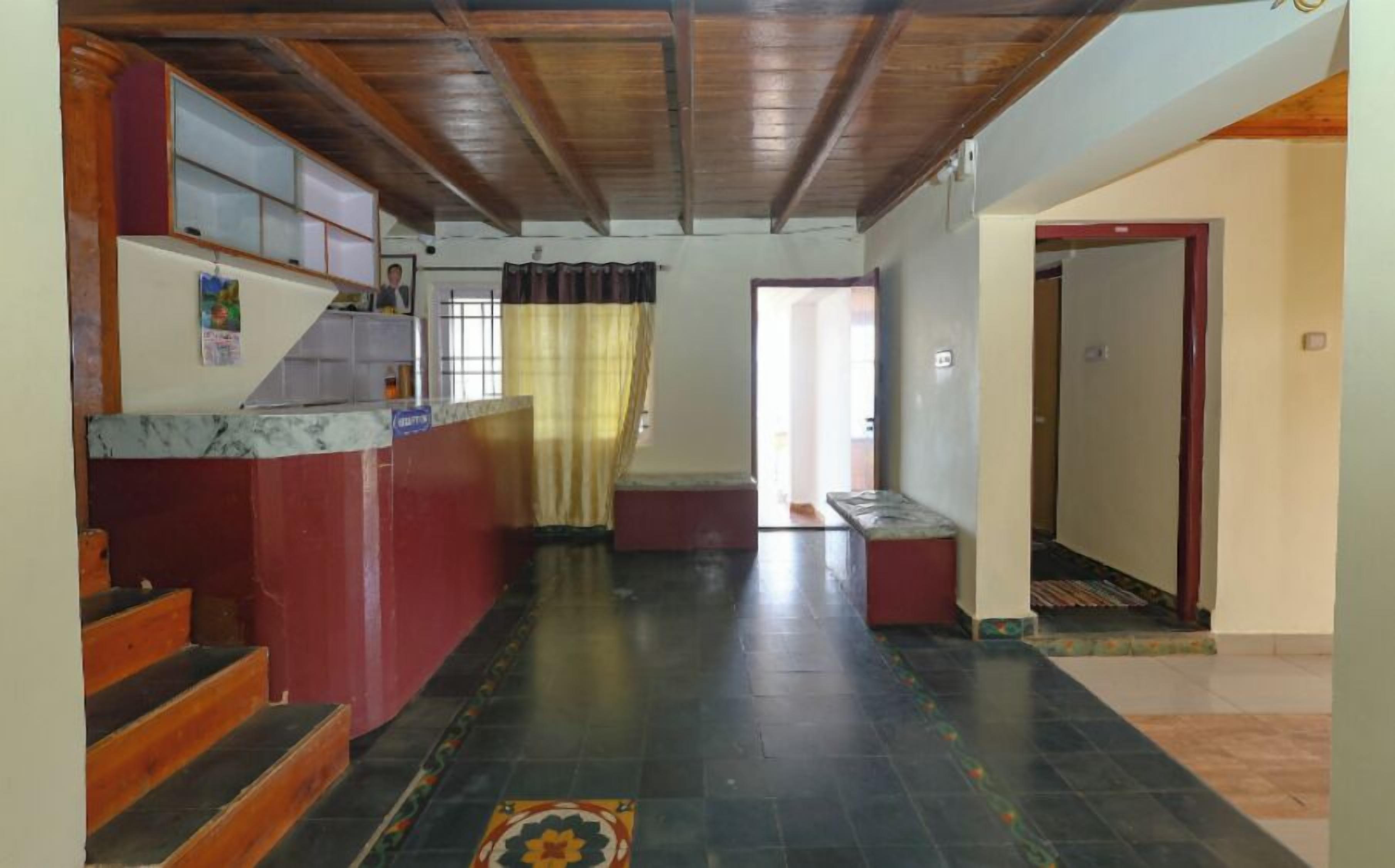 A hallway with a staircase, a bench, and a door.