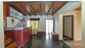 A hotel lobby with a marble reception desk, a staircase, and a view of the entrance. - Mistora Valley (Ooty)